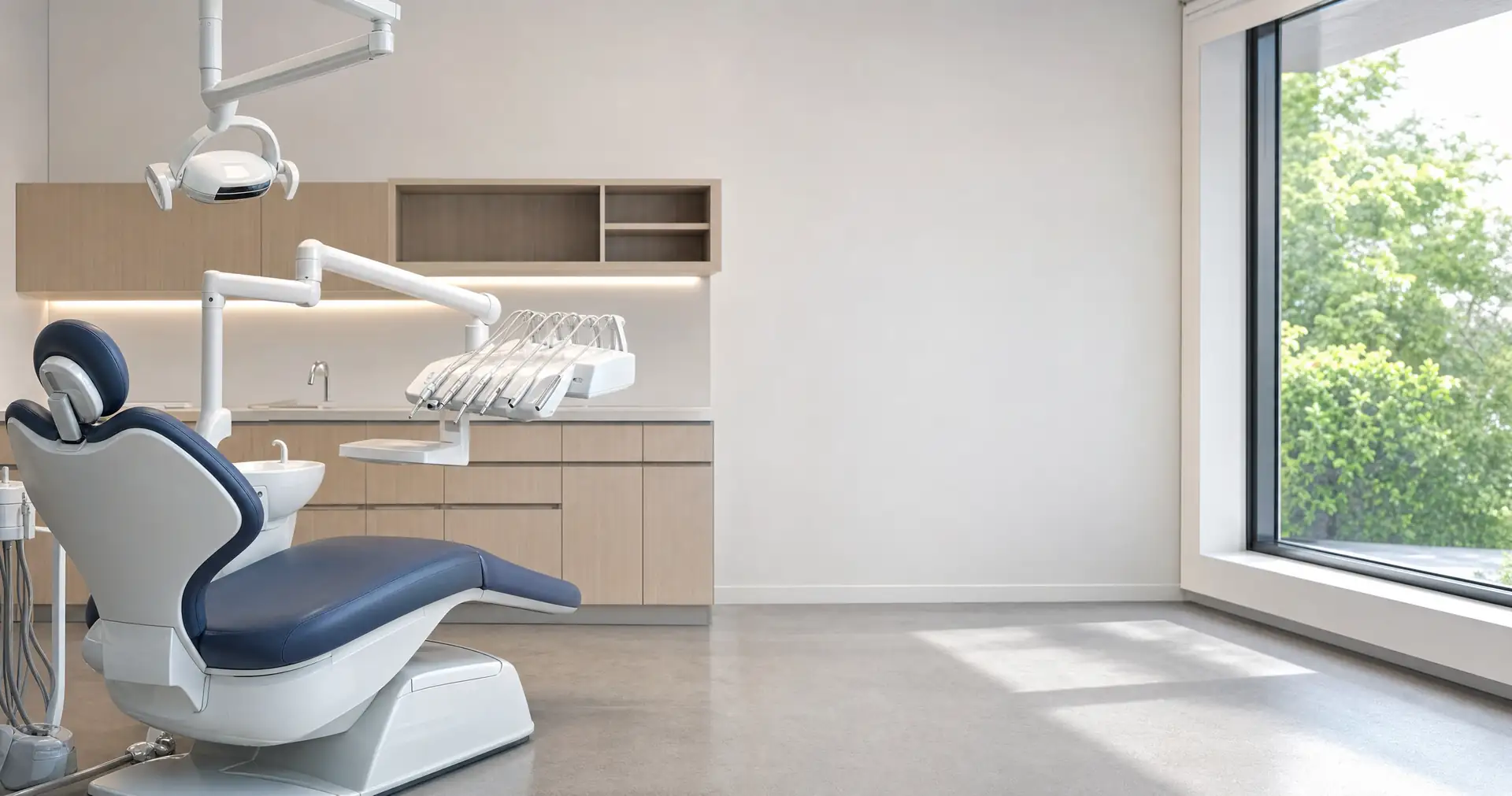 A dental treatment chair with its overhead light folded back in an empty surgery