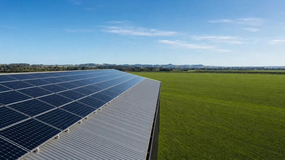 An array of solar panels mounted across the roof of a commercial shed