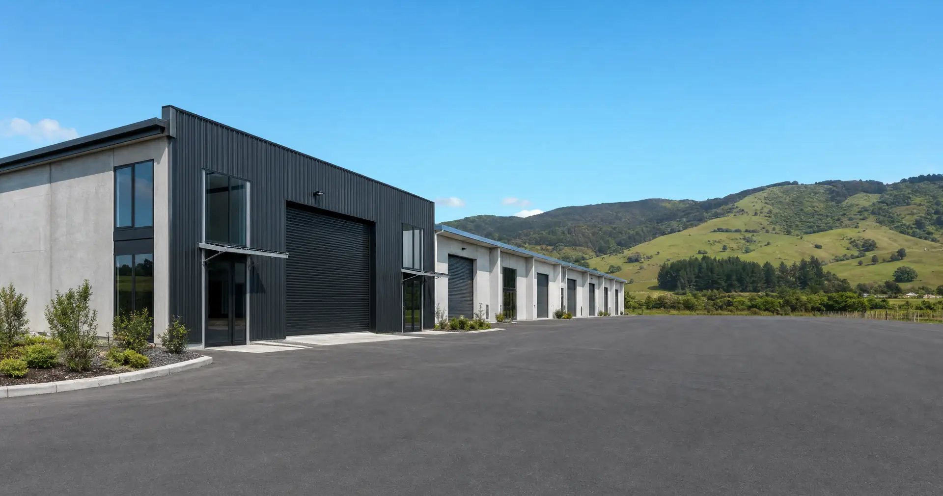 A small light-industrial estate of tilt-slab units seen across a sealed carpark